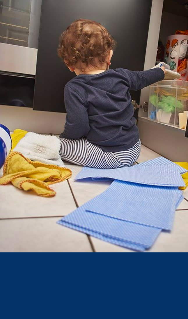 Barn leker i kjøkkenskapet