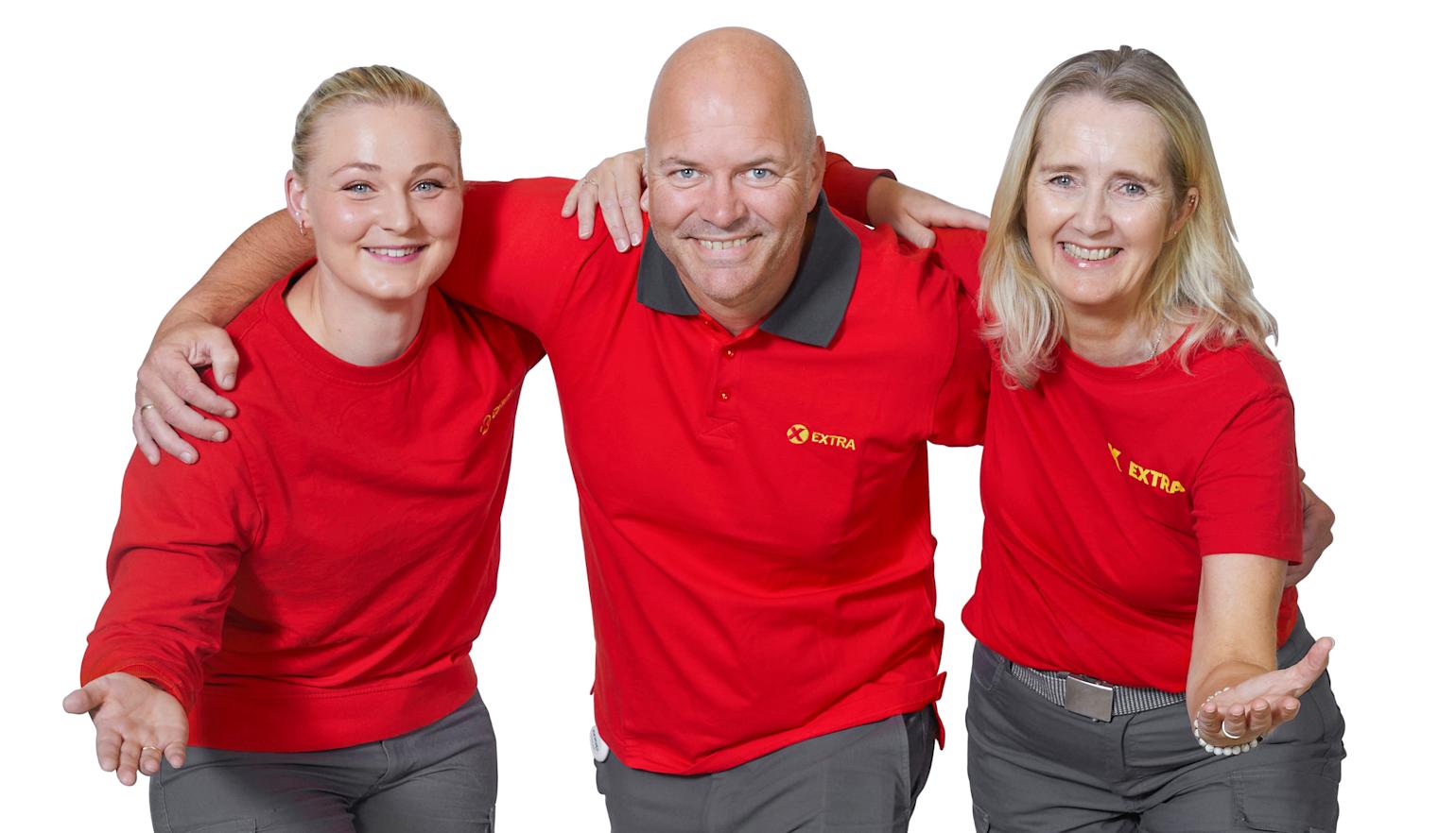 Tre ansatte i Extra står foran butikk