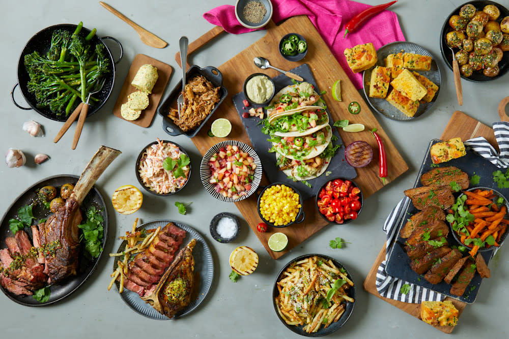 Alle Coop Grill Perfekt sine Low and slow produkter, tilberedt med tilbehør på fat og i skåler; Tomahawk, brisket, T-bone steak og svinenakke.