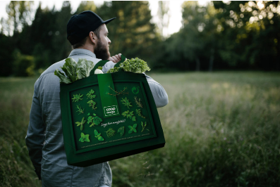 Mann med gjenbrukbart handlenett på skulderen med grønnsaker i