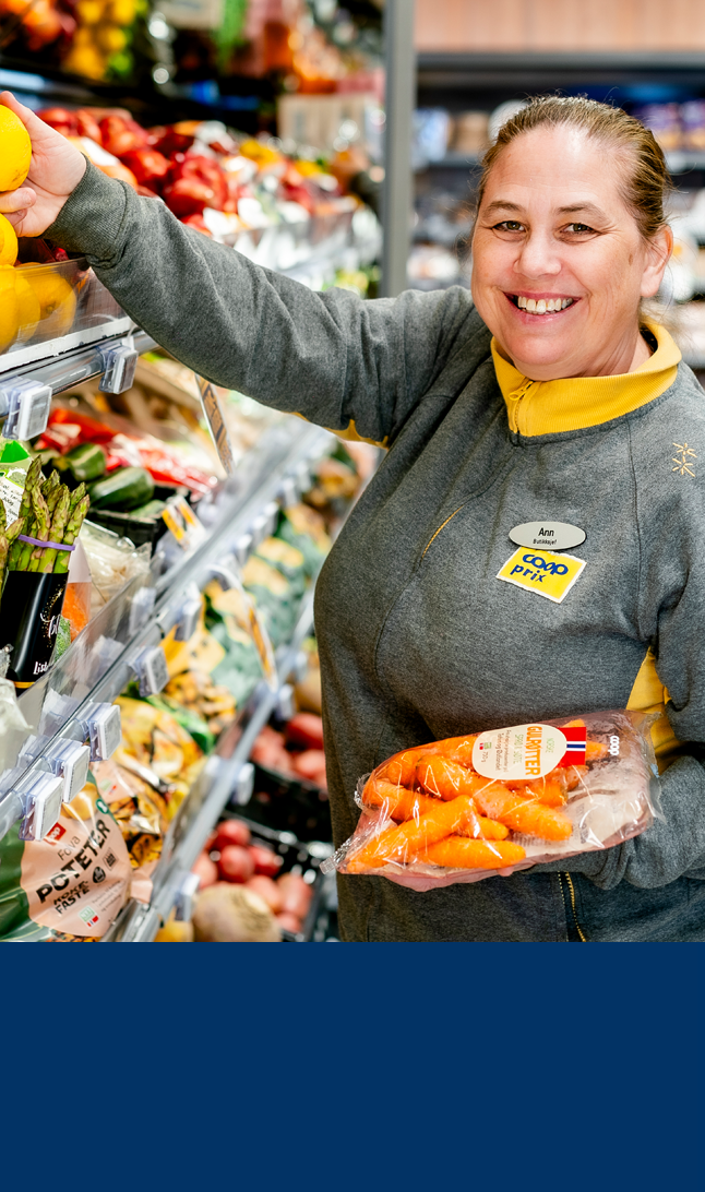 Blid dame i Coop Prix butikk fyller på hyller