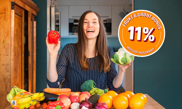 Lise smiler og har et bord foran seg med masse frukt og grønt