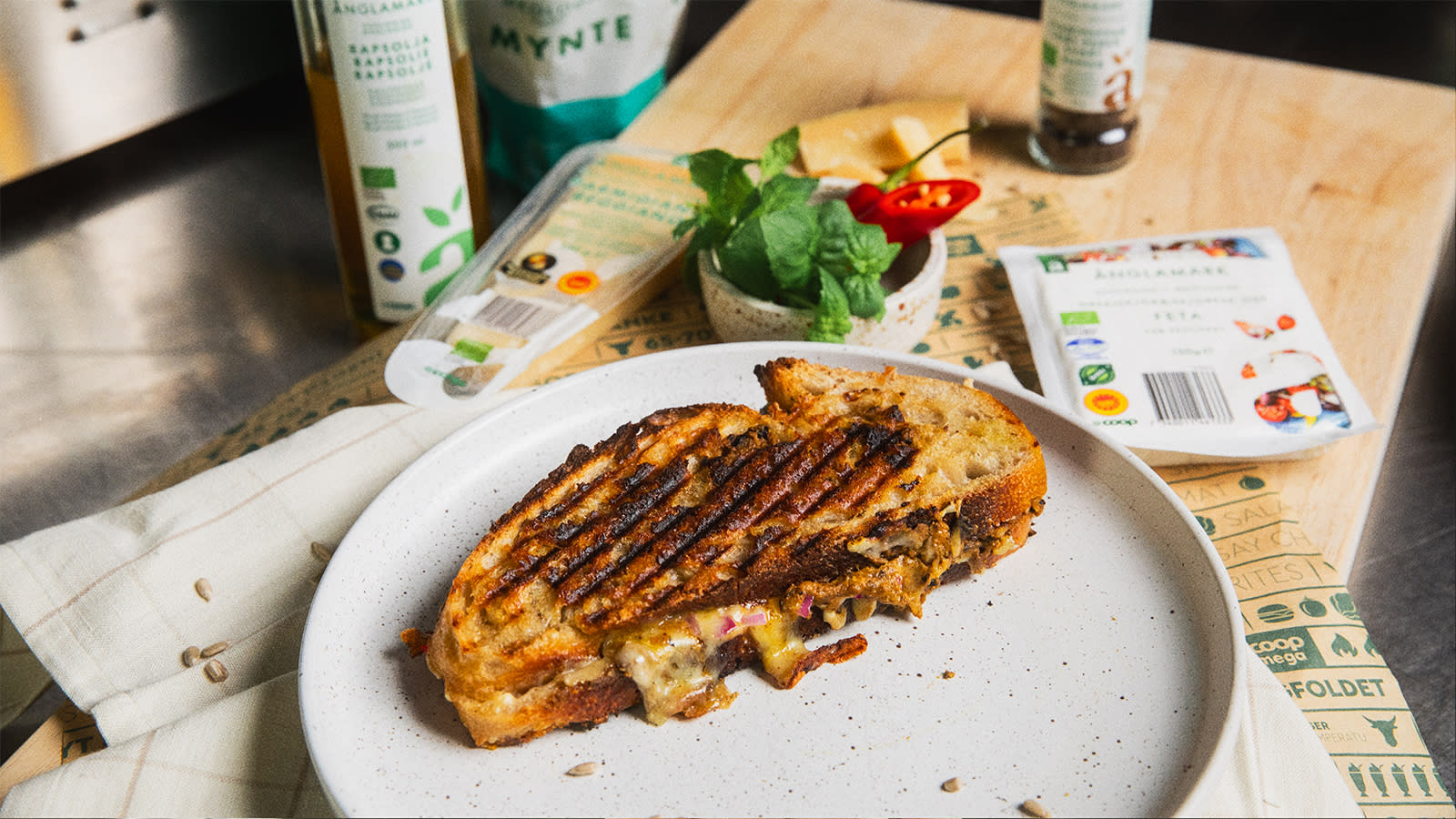 Änglamark-toasten, toasten fra Coop Mega standen fra Øya festivalen, ligger på lys tallerken på trefjøl omringet av forskjellig Änglamark ost.