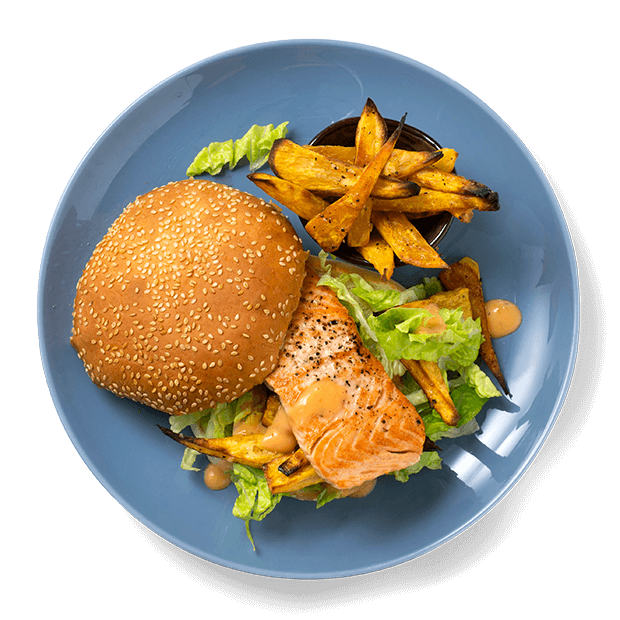 Laksefilet i burgerbrød, servert med salat, dressing og hjemmelagede søtpotetfries.