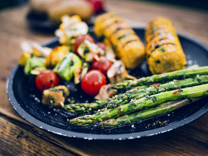 Fat med grillet asparges, grillede maiskolber og grillspidd med tomater og sopp. 