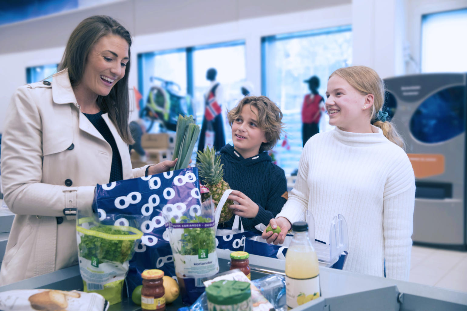 Familie pakker varer i butikk